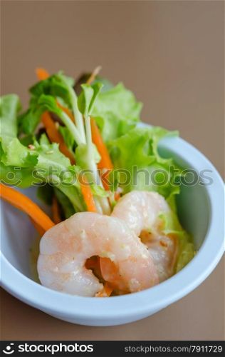 green salad with shrimp. Oak leaf lettuce salad with shrimps in blue bowl