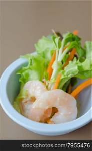 green salad with shrimp. Oak leaf lettuce salad with shrimps in blue bowl
