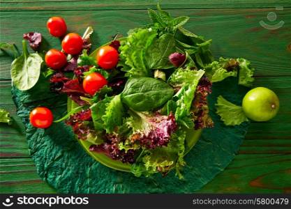 Green salad with spinach lettuce tomatoes feta cheese on monochrome wood