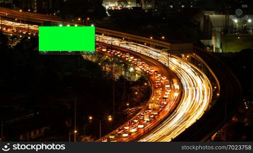 Green screen billboard with traffic jam on road at highway for advertising in urban city, Bangkok , Thailand at night.