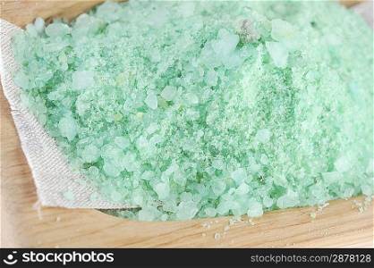 Green sea salt for bathing isolated on wooden tray