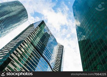green skyscrapers under blue sky with white clouds in business district of Moscow city in autumn