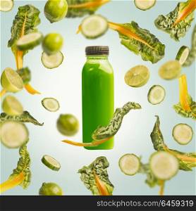 Green smoothie bottle with flying or falling ingredients: citrus fruits, cucumber and chard leaves on light blue background. Healthy detox beverages. Detox, dieting, clean eating