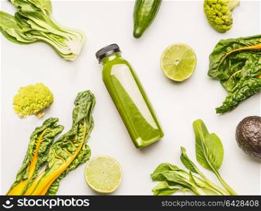 Green smoothie bottle with ingredients on white desk background, top view, flat lay. Healthy clean and detox, weight loss dieting or fasting food concept
