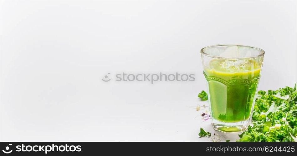 Green smoothie glass and kale on light background, side view, place for text, banner. Healthy lifestyle or detox diet food concept.
