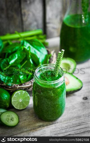 Green smoothie on rustic wooden background