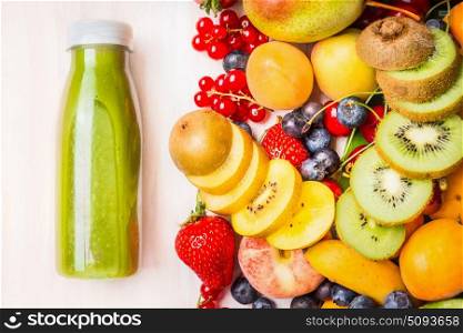 Green smoothie or juice with various fruits and berries ingredients on white wooden background, top view