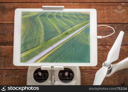 green soybean fields in a valley of the Missouri River, near Glasgow, MO, reviewing drone aerial image on a digital tablet