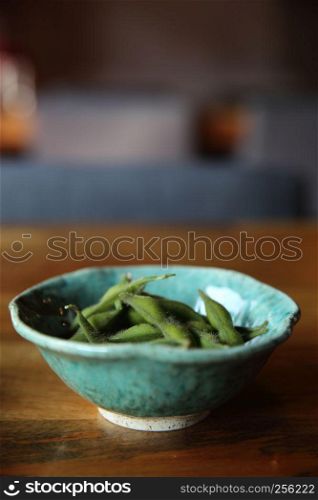 Green soybean on wood background