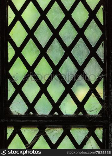 Green stained glass window with regular block pattern as background