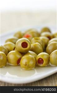 green stuffed olives in a white dish