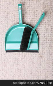 Green sweeping brush and dustpan for house work on floor indoors. Cleaning