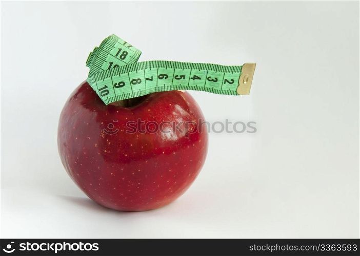 Green tape Measure with red Apple. Isolated on white