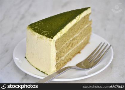 Green tea cake on table with fork