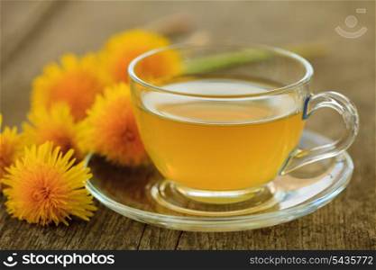 Green tea in glass cup and flowers on wooden table