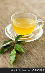 Green tea in glass cup on wooden table