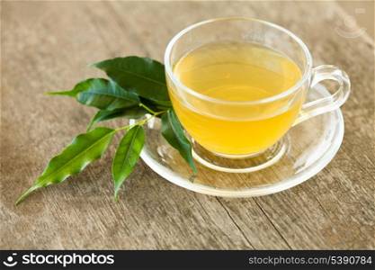 Green tea in glass cup on wooden table