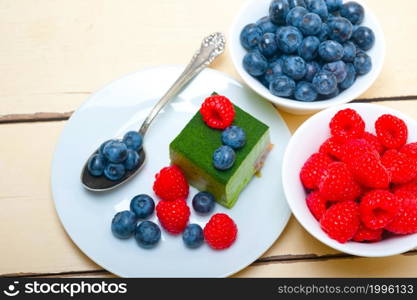 green tea matcha mousse cake with raspberries and blueberries on top