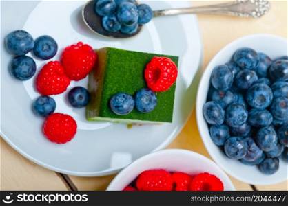 green tea matcha mousse cake with raspberries and blueberries on top