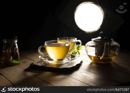 Green tea on a wooden table with a teapot