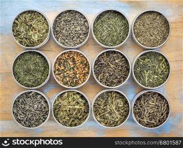 green tea sampler - top view of loose leaf teas in metal cans against grunge wood