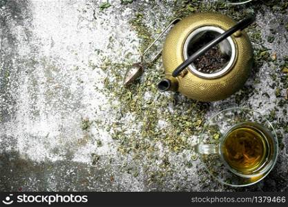 Green tea with a teapot. On a rustic background.. Green tea with a teapot.