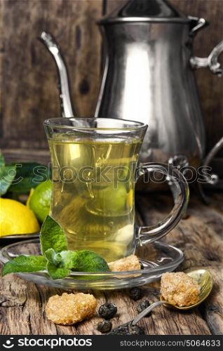 green tea with lime and mint. tea brewed with lime and mint on wooden background