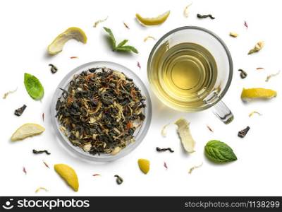 Green tea with natural aromatic additives and a cup. Top view on white background.. Green tea with natural aromatic additives and a cup. Top view on white background