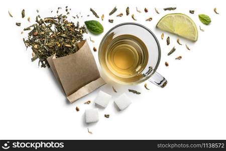 Green tea with natural aromatic additives and a cup. Top view on white background.. Green tea with natural aromatic additives and a cup. Top view on white background