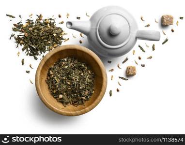 Green tea with natural aromatic additives and a teapot. Top view on white background.. Green tea with natural aromatic additives and a teapot. Top view on white background