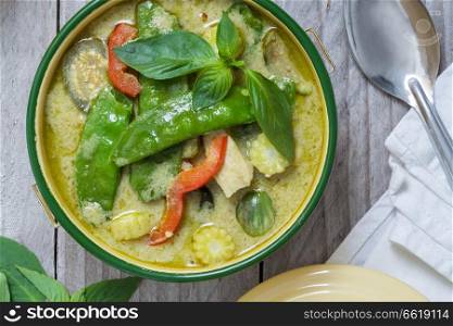 Green Thai curry in a bowl on wooden table.. Green Thai curry in a bowl on wooden table