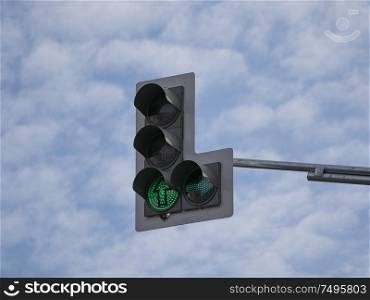 Green traffic light with an additional section against a cloudy sky.. Green traffic light with an additional section against a cloudy sky