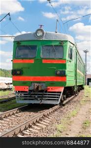 Green train is on a railway line