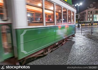 Green tram in Lisbon at night.