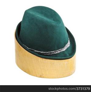 green tyrolean felt hat on linden wooden hat block isolated on white background