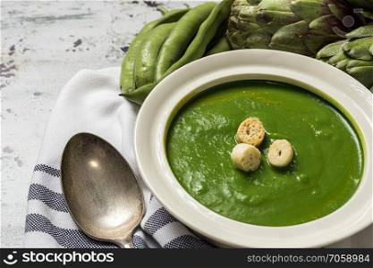 Green vegetable cream soup on wooden board. Detox