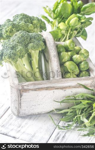 Green vegetables with herbs in the wooden basket