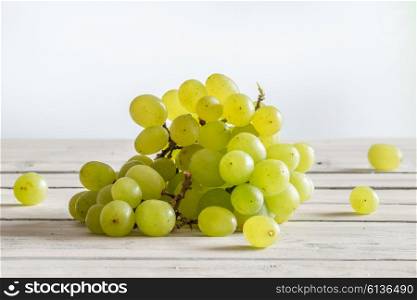 Green vine grapes on a wooden kitchen table