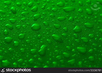 Green water drops background with yellow reflections.