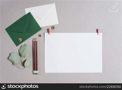 green white envelope pencils blank paper gray backdrop