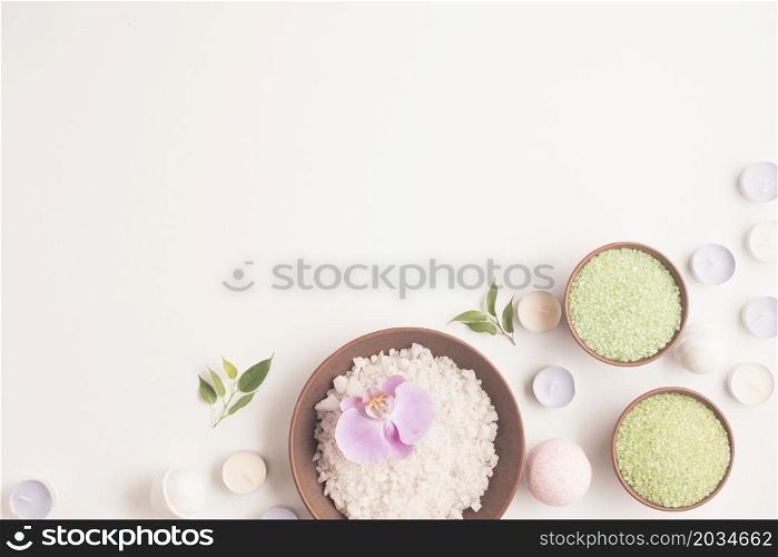 green white herbal sea salt with many small candles white backdrop
