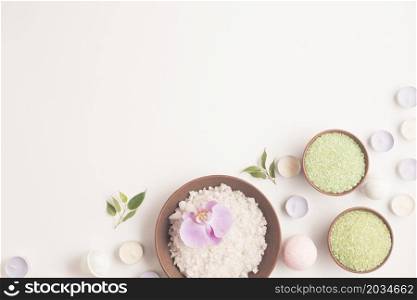 green white herbal sea salt with many small candles white backdrop