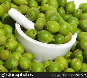 Green young walnuts in husks in pounder