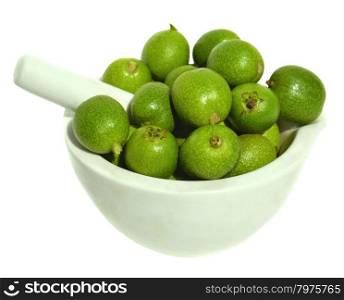 Green young walnuts in pounder on white background