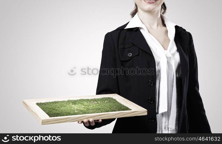 Greenery concept. Close up of businesswoman holding wooden frame with green tree