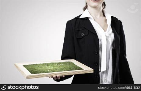 Greenery concept. Close up of businesswoman holding wooden frame with green tree