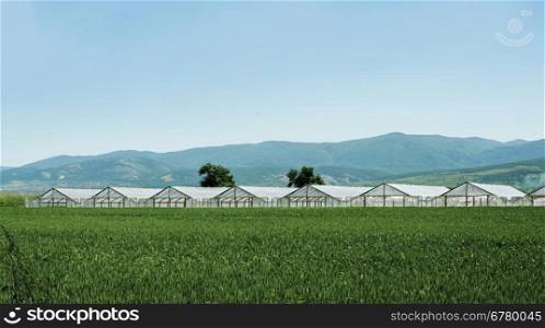 Greenhouse plantation and cultivated land on the foreground