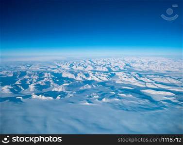 Greenland frozen landscape aerial view shot from plane. Complex Snow Mountains Stunning valley and glacier