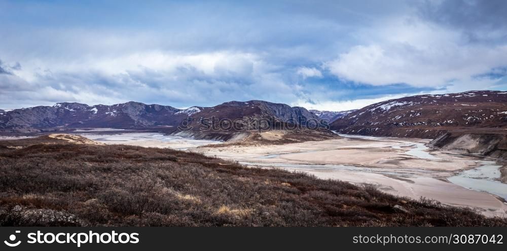 Greenlandic wastelands landscape with river and mountains in the background, Kangerlussuaq, Greenland