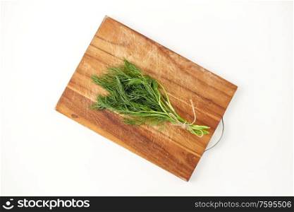 greens, culinary and ethnoscience concept - bunch of dill on wooden cutting board. bunch of dill on wooden cutting board